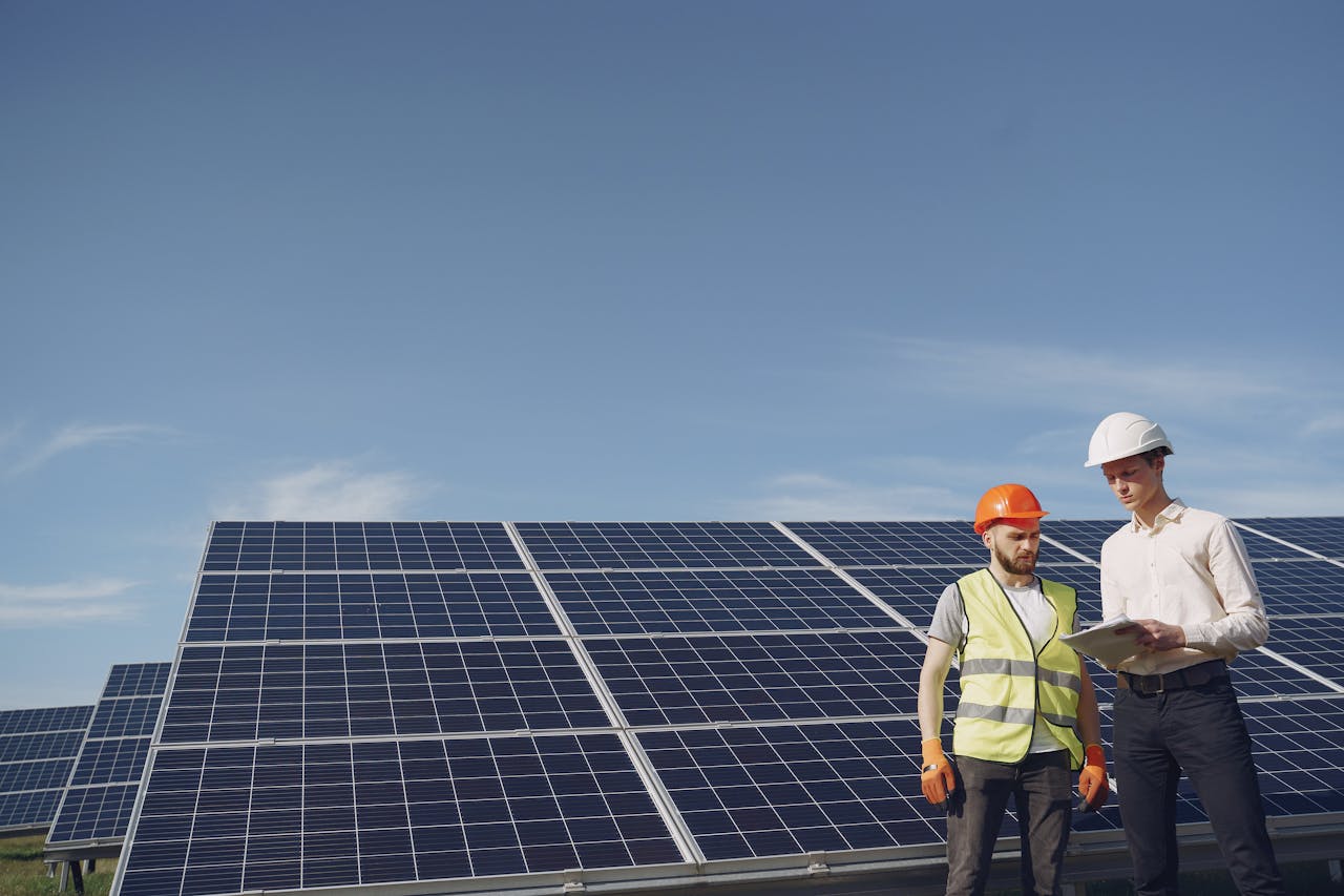 Two engineers inspecting a solar panel array to ensure efficiency and sustainability.